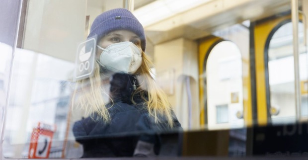 Frau mit Schutzmaske in einer Straßenbahn.