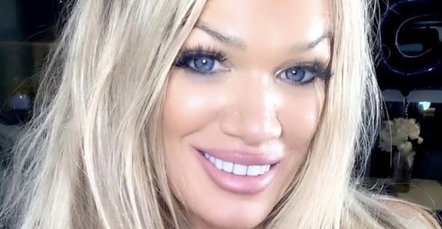 Eine blonde, starkgeschminkte Frau mit langen offenen Haaren.