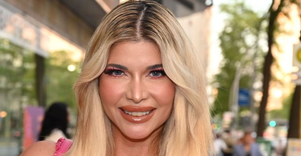Michaela Schäfer mit blonden langen Haaren und viel Make Up auf der Straße.
