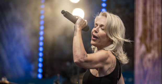 Schlagerstar Michelle mit offenen blonden Haaren, einem Mikrofon singend auf der Bühne.