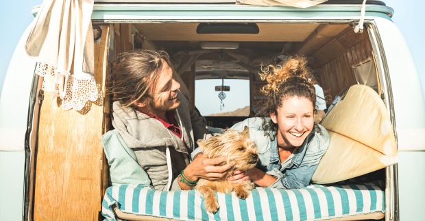 Paar fährt mit Hund surfen | Credit: iStock.com/ViewApart