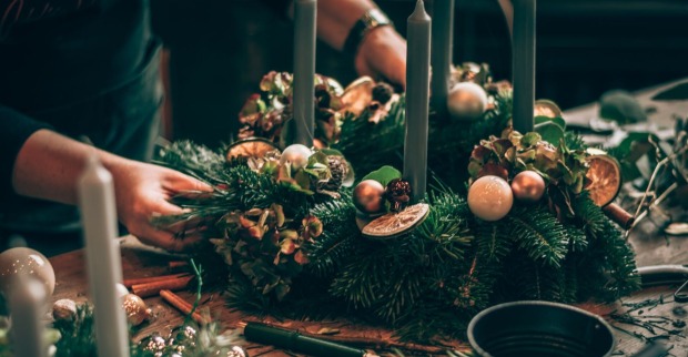 Eine Frau bindet einen Adventkranz.
