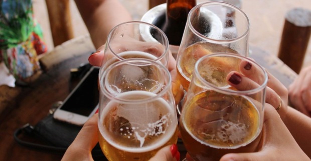 Vier Mencshen stoßen mit Bier an