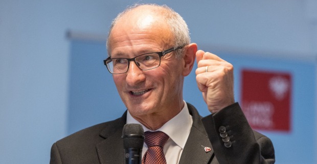 Anton Mattle im Portrait mit einem Mikrofon in der Hand