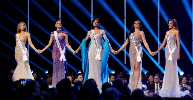 Bewerberinnen für die Miss Universe 2023 stehen auf einer Bühne in langen Abendkleidern.