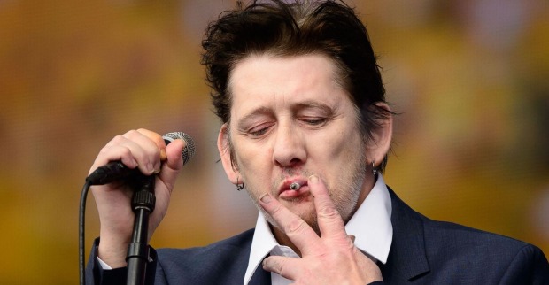 Shane MacGowan 2014 rauchend auf der Bühne.