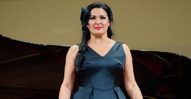 Anna Netrebko in einem blauen Ballkleid und einer eleganten Frisur.