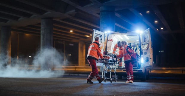 Einsatzkräfte bringen Verletzten in einen Krankenwagen.