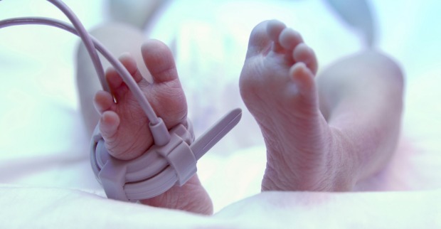 Ein Baby im Krankenhaus, man sieht nur die Füße.