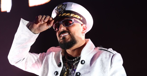 Gigi D'Agostino mit einem weißen Hut und einem weißen Sakko.