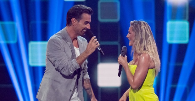 Helene Fischer und Florian Silbereisen auf der Bühne. Er trägt ein graues Sakko und sie einen gelben Jumpsuit.