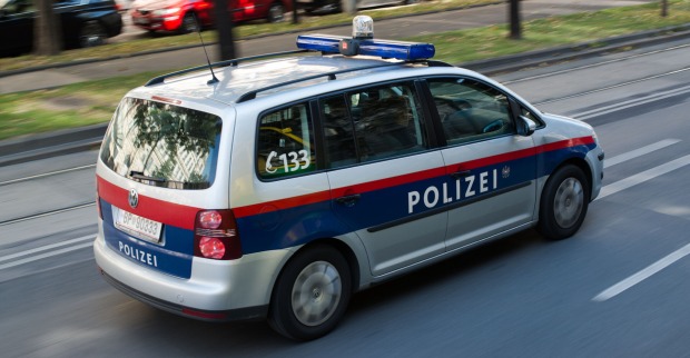 Ein Polizeiauto fährt auf einer Wiener Straße.