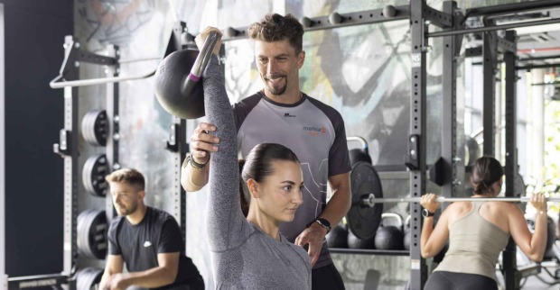 Menschen trainieren in einem Fitnessstudio.