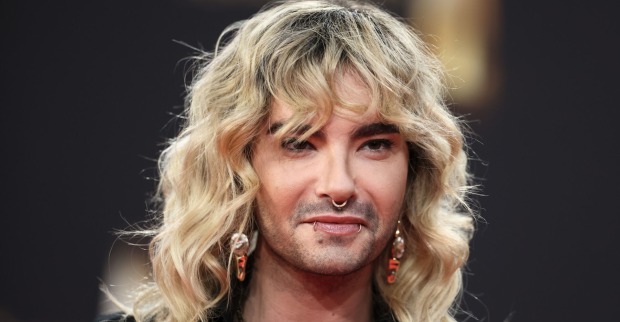 Bill Kaulitz mit blonden gewellten Haaren und Piercings im Gesicht.
