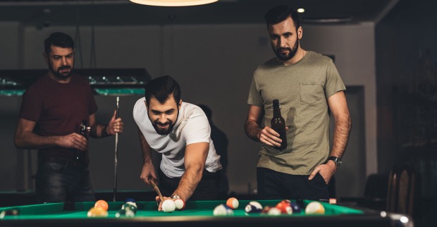 Männer spielen in der Männerhöhle Billard | Credit: iStock.com/LightFieldStudios