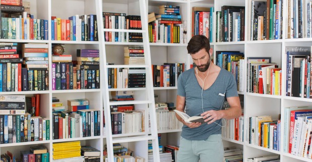 Mann steht bei seinen Bücherregalen | Credit: iStock.com/Astronaut Images