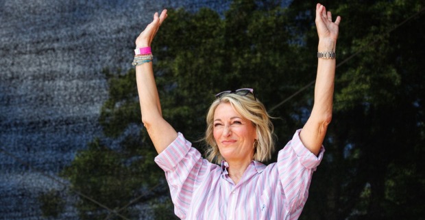 Monika Gruber streckt die Hände nach oben.
