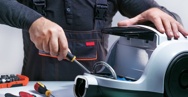 Handwerker repariert grauen Staubsauger | Credit: Sergei Chuyko/istock.com