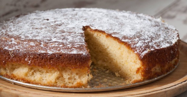 Angeschnittener Kuchen auf einem Servierteller, bei dem bereits ein Stück fehlt