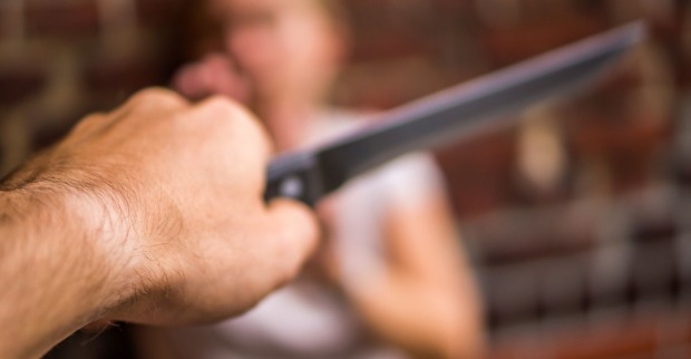 Ein Mann bedroht einen Frau mit dem Messer.