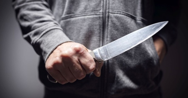 Ein Mann mit einem großen Messer in der Hand.
