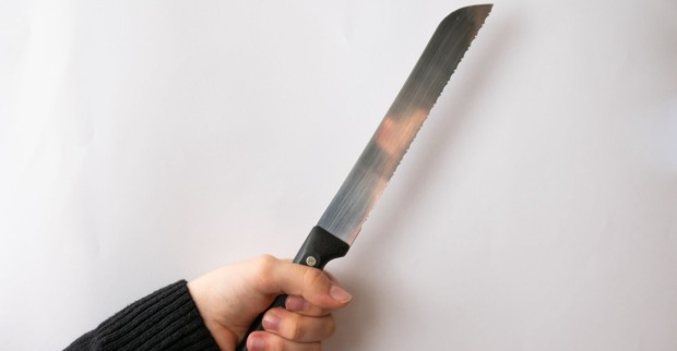 Eine Person hält ein Brotmesser in der Hand.