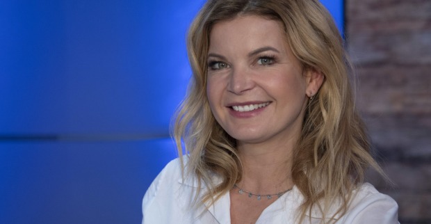 Eva Imhof mit einer weißen Bluse und gewellten blonden Haaren.