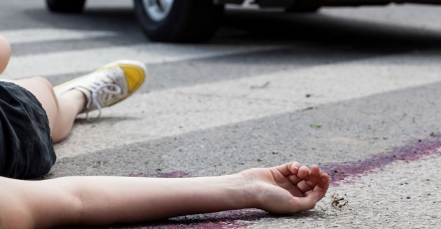 Ein Frau liegt nach einem Unfall auf der Straße.