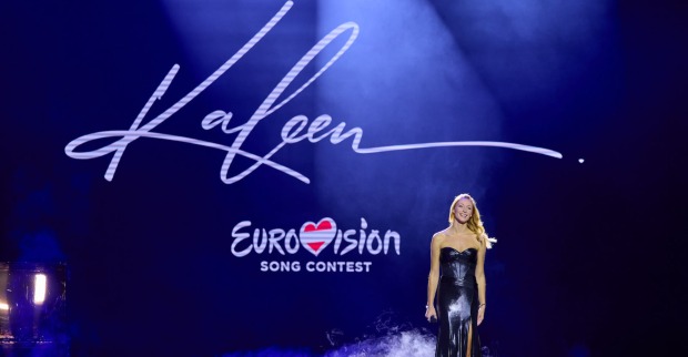 Kaleen auf der Bühne. Dahinter steht "Eurovision Song Contest". Sie trägt ein langes, schwarzes Ballkleid.