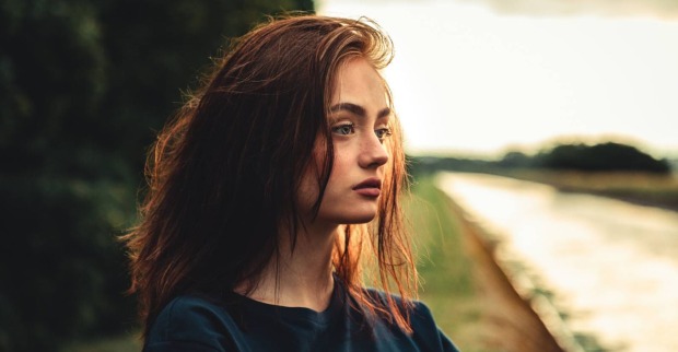 Nahaufnahme des Gesichts einer jungen Frau mit in die Ferne gerichtetem Blick