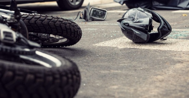 Ein Motorrad und ein Helm liegen nach einem Unfall auf der Straße.