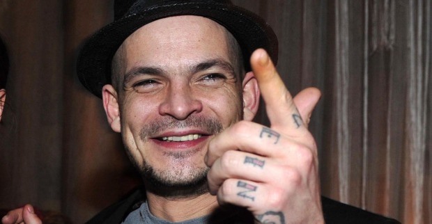 Ben Tewaag mit Tattoos auf den Händen und einem Hut.
