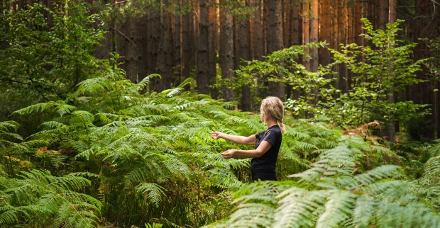 Frau steht mitten im Wald | Credit: iStock.com/ed chechine