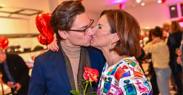 Claudia Obert küsst ihren Partner Max Suhr und hält eine Rose in der Hand.