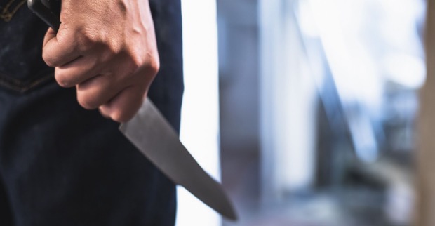 Ein Mann mit einen Küchenmesser in der Hand.