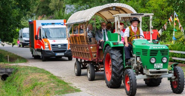 Traktorausfahrt mit Anhänger, dahinter ein Rettungswagen.