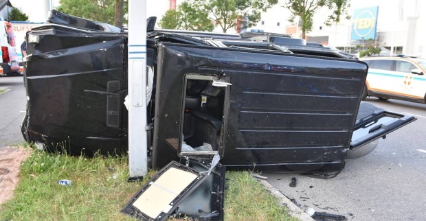 Schwarzer Unfallwagen kracht gegen Lichtmast.