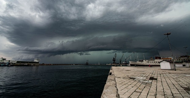 Unwetterfront zieht über einen Badeort am Meer.