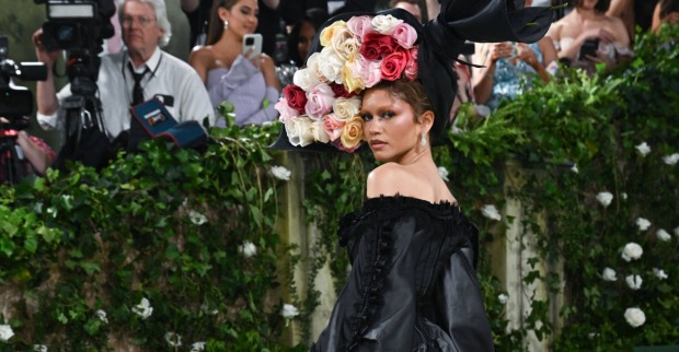 Frau in schwarzem Kleid mit großem Blumen-Hut