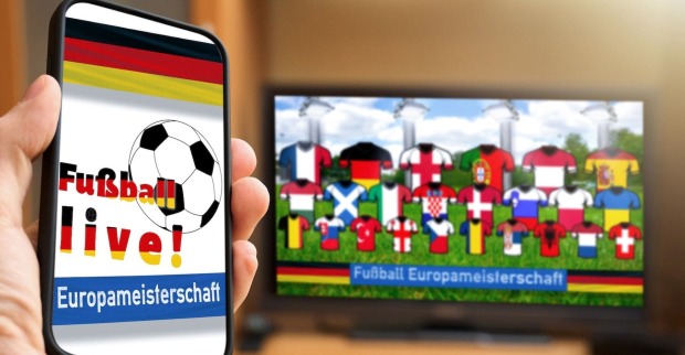 Bildschirm mit Landestrikots, Handy mit Liveticker