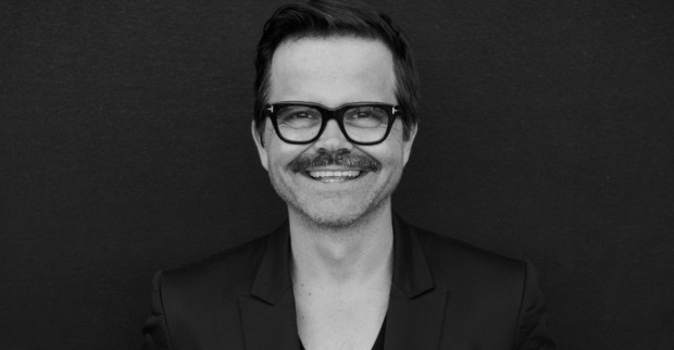 Ein schwarz-weißes Foto von einem Mann mit Brille