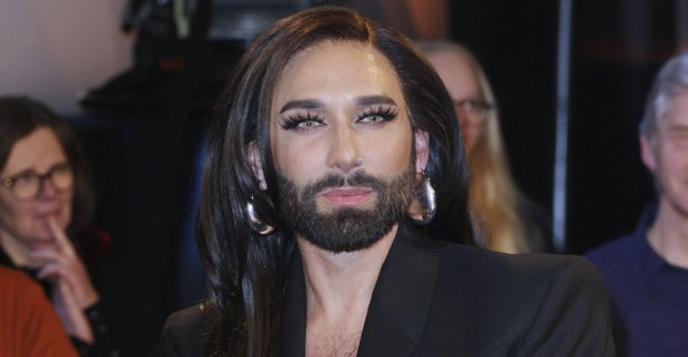 Conchita Wurst mit einem schwarzen Sakko und langen schwarzen Haaren.