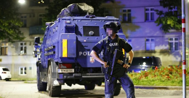 Ein Polizist vor dem Panzerwagen der Wega in der Nacht