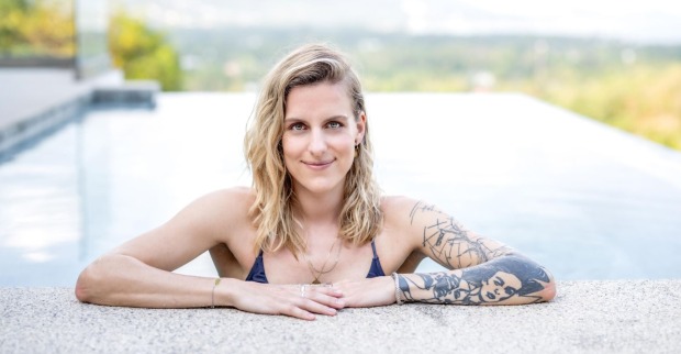 Die neue Princess Charming mit offenen blonden Haaren und einem Tattoo am Arm im Pool.