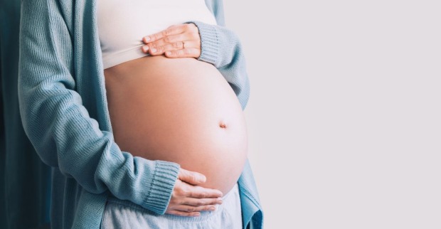 Schwangere Frau, die ihren Bauch hält