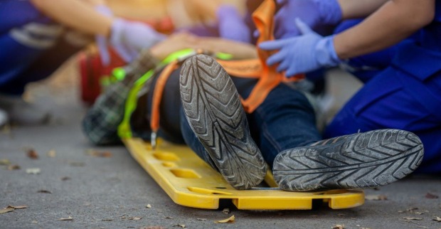 Einsatzkräfte kümmern sich um ein Unfallopfer auf einer Trage.