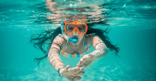 Eine Frau schnorchelt im blauen Meer