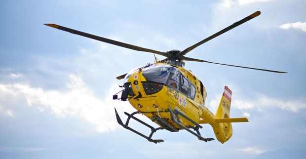 Ein gelber ÖAMTC-Rettungshubschrauber in der Luft.