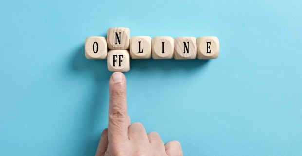 Finger der den Buchstaben N vom Wort Online wegschiebt mit einem Doppel-F Stein, damit das Wort offline ergibt