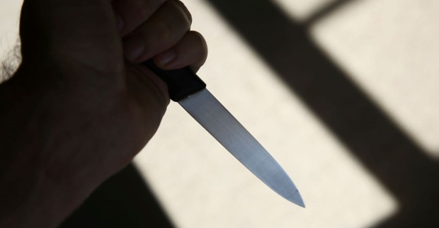 Ein Mann hält ein Messer in der Hand.
